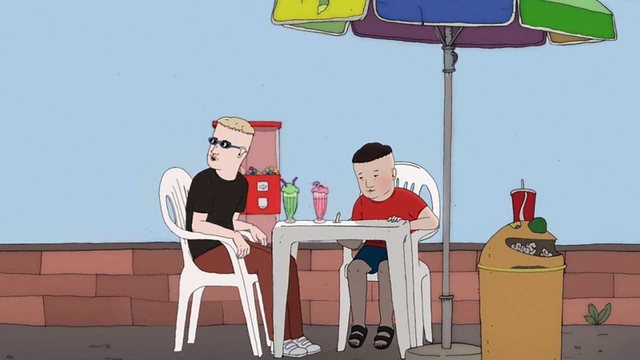 Still from Easter Eggs. Two teenagers are seated at an outdoor plastic table having milkshakes. Kevin, on the left, looks away at something happening offscreen. On the right, Jason looks down with a downtrodden look on his face.